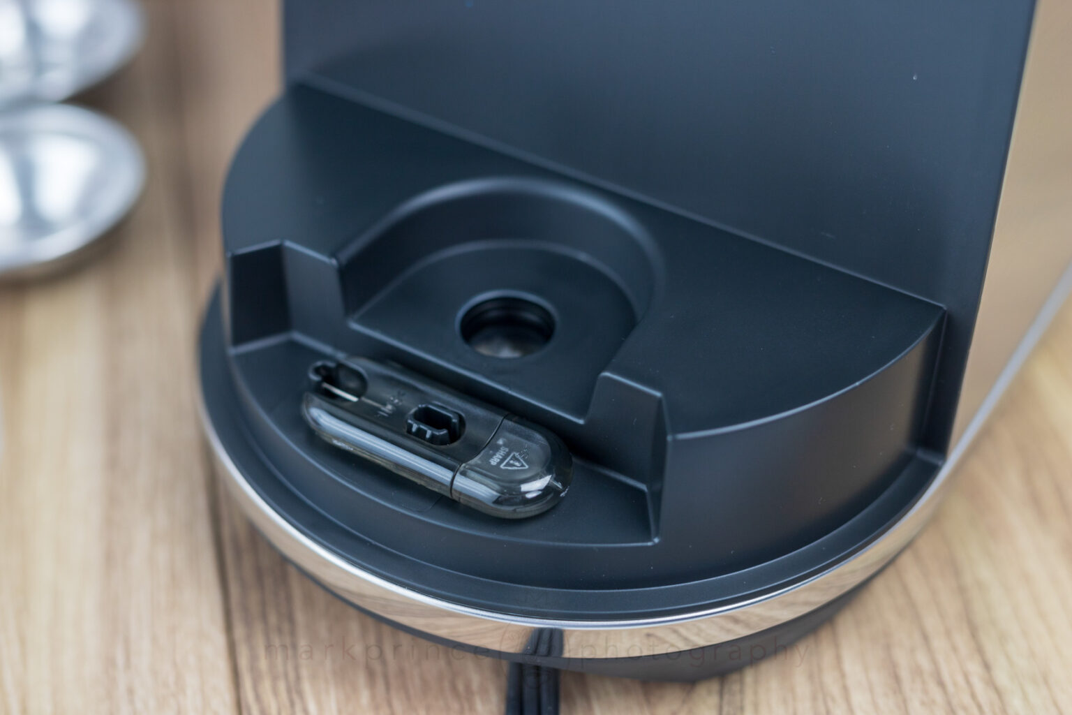 The wand cleaning tool, stored beneath the water reservoir.