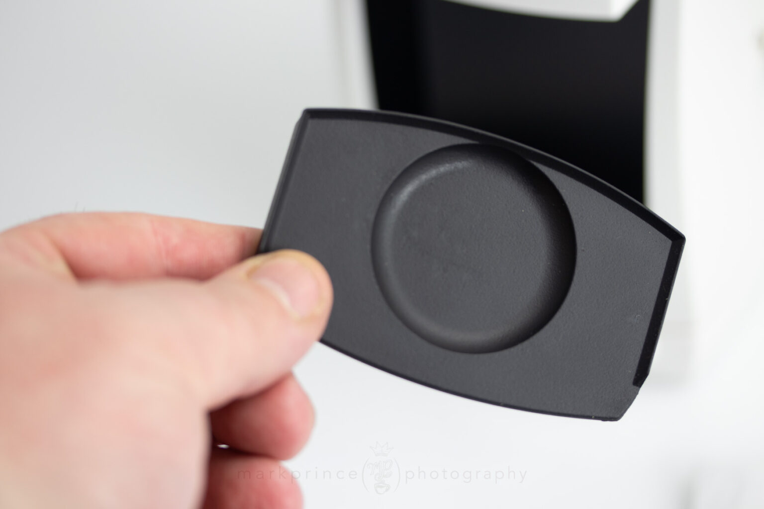 The removable dosing cup plate is made of some kind of rubber material. The lip side goes inside the grinds bin area.