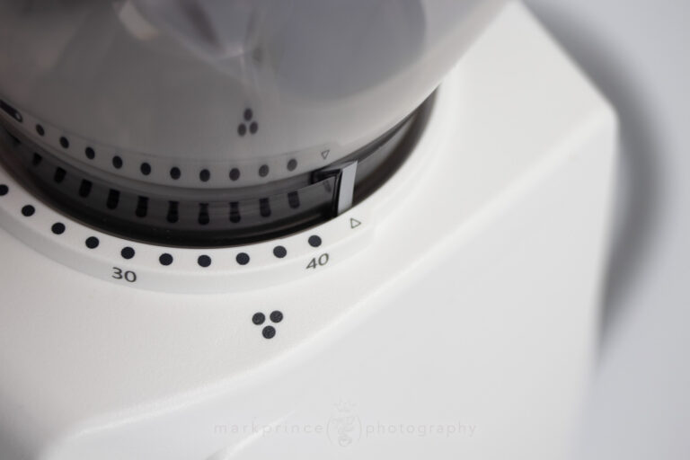 To remove the bean hopper to get to the burrs, just rotate the hopper until the silver tab lines up at this point.