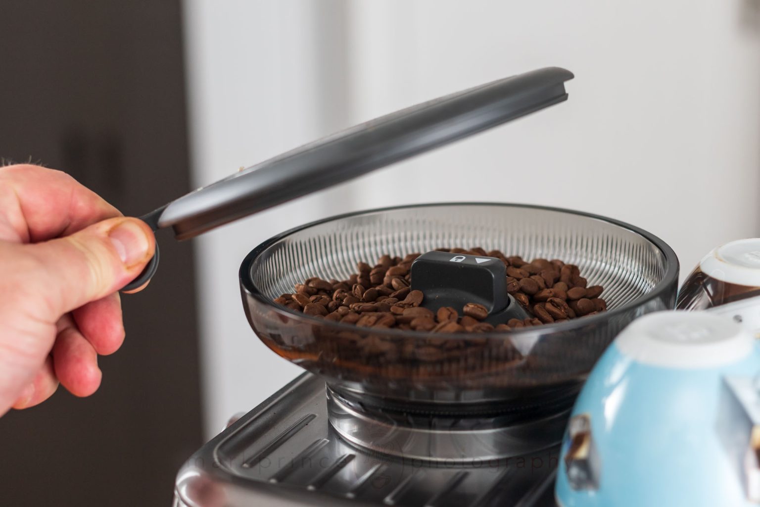 The Bean Hopper holds 12oz, and has a tight sealing lid.